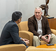 two colleagues sitting in chairs talking