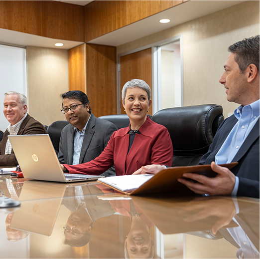 smiling executives sitting around a conference table